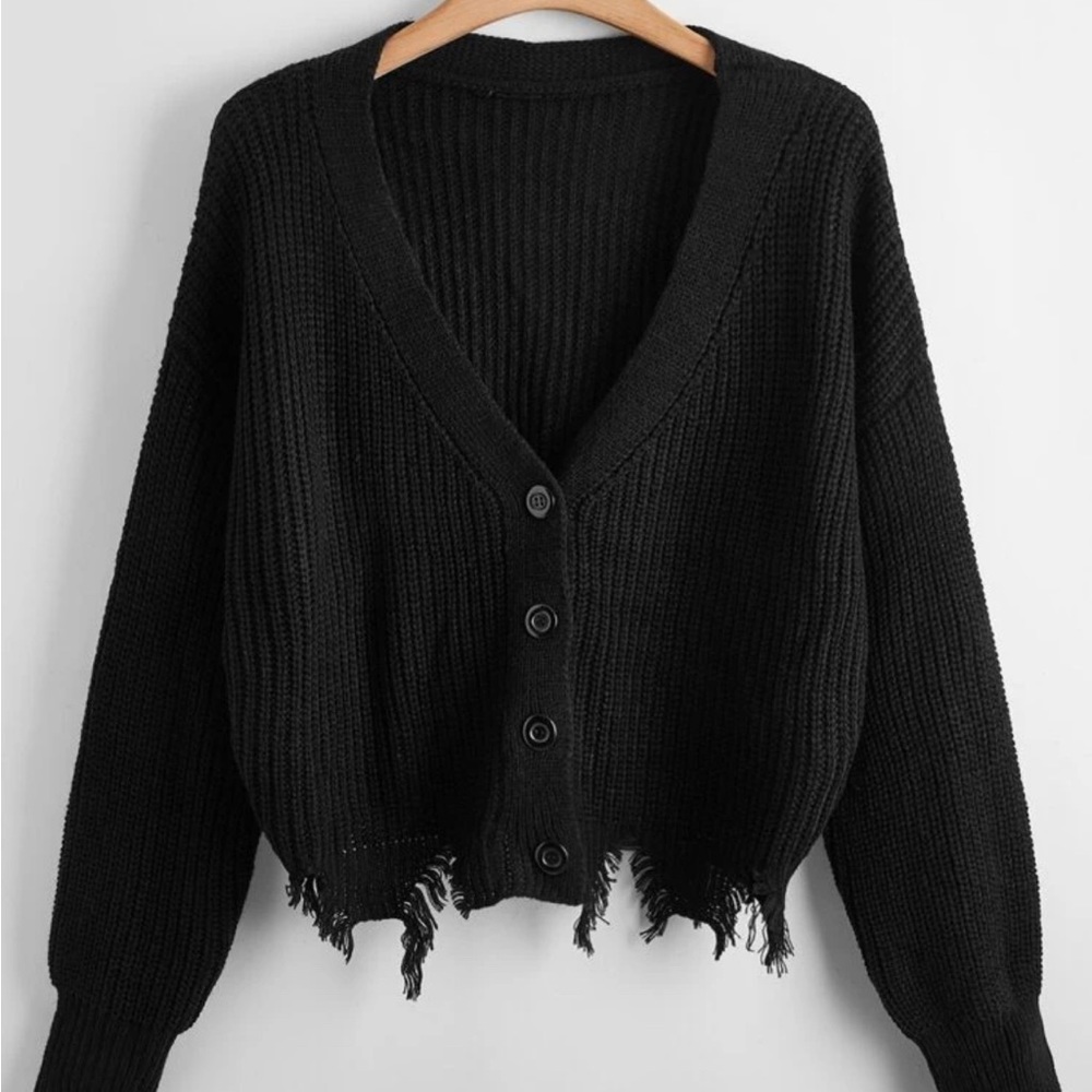 Black knit sweater rip at the bottom